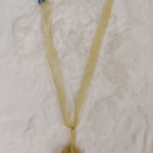 Κίτρινη δέστρα από οργάντζα με σχέδιο φουντάκι και μήκος δεσιάς 40 εκατοστά.