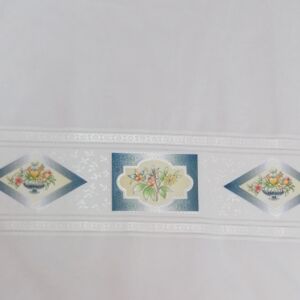 Γαζα βαμβακερή σε λευκό χρώμα με μπλε λουλούδια στο κάτω μέρος και φάρδος τοπιού 2.80 μέτρα.