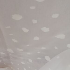 Υφασμα από διάφανη γάζα σε λευκή απόχρωση με σχέδιο λευκές βούλες και με φάρδος τοπιού 2.80 μέτρα.